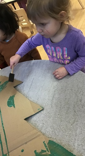 Toddler painting cardboard christmas tree