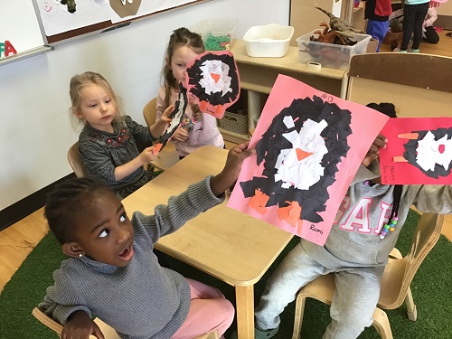 Children showing their ripped paper pieces penguin