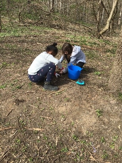 2 school age children digging for worms 