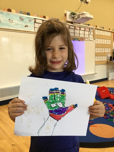 Jkk Child displaying an colourful, artistic drawing of their hand 