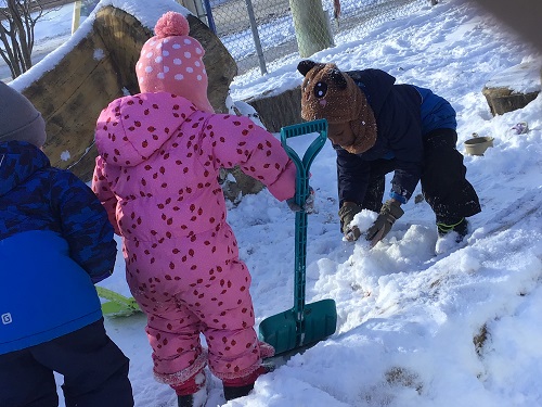 3 preschool children shoveling snow