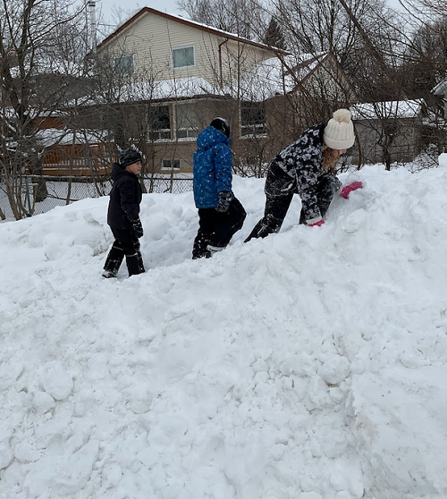 children climbing snow hill