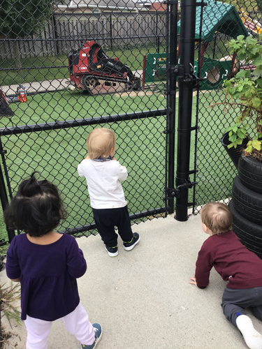 kids watching their playground renos from the other side of the fence