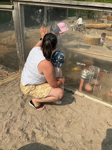 Educator and children communicating through Plexi-glass