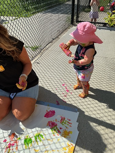 Child pouring paint onto her hands