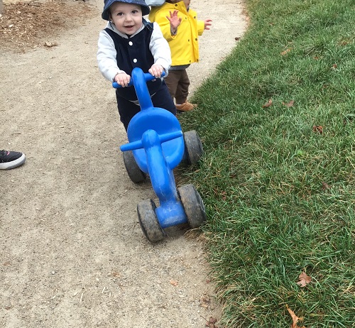 An infant walking using a riding toy