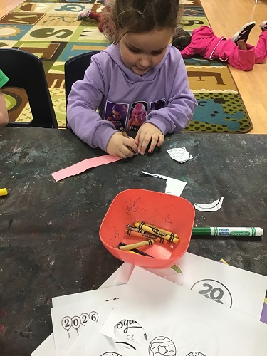 A child writting on a strip of paper