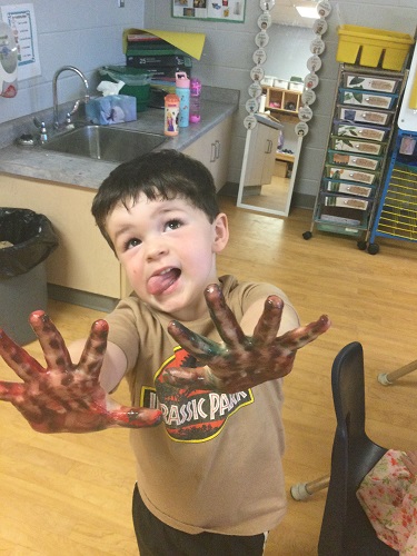 A child with paint on their hands