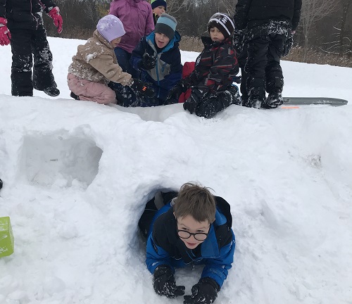 Children digging tunnels in the snow