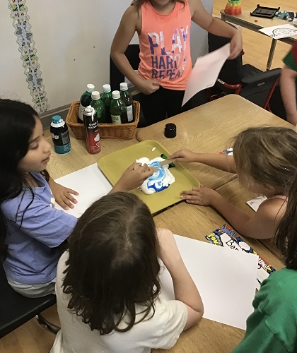 school aged children mixing food colouring in shaving foam