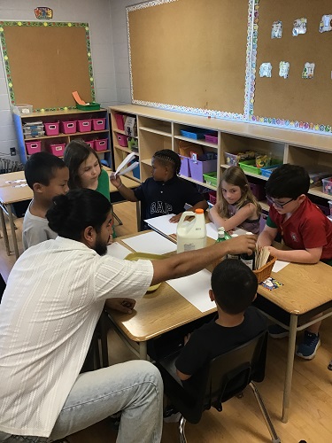 Educator and school aged children preparing the activity