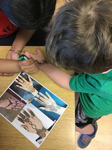 Summer camp child getting a henna design