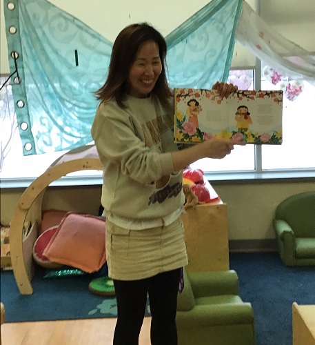 An educator reading a book about Lunar New Year to the toddlers