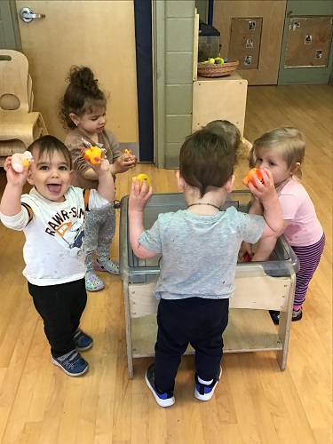 Toddlers playing with rubber ducks