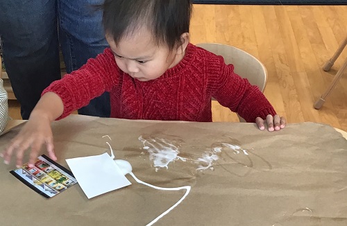 A child gluing pictures to a piece of paper