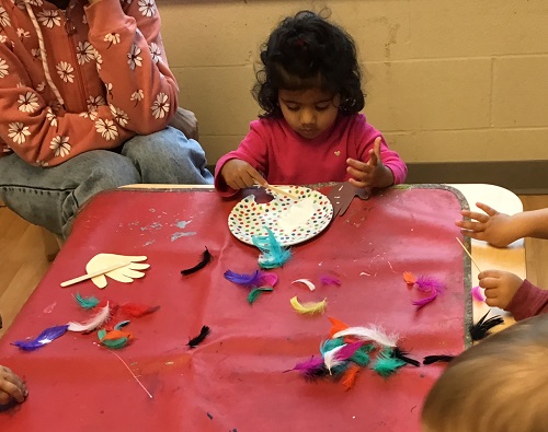 A toddler exploring craft supplies